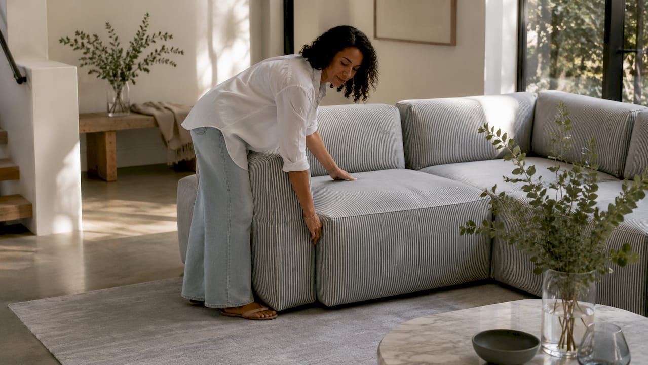 Woman arranging modular sofa units in living room
