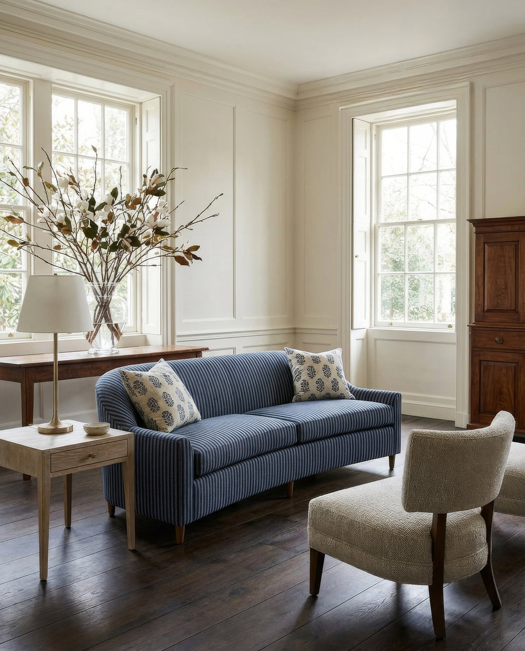 Living room with a blue striped sofa, beige armchair, and wooden coffee table.