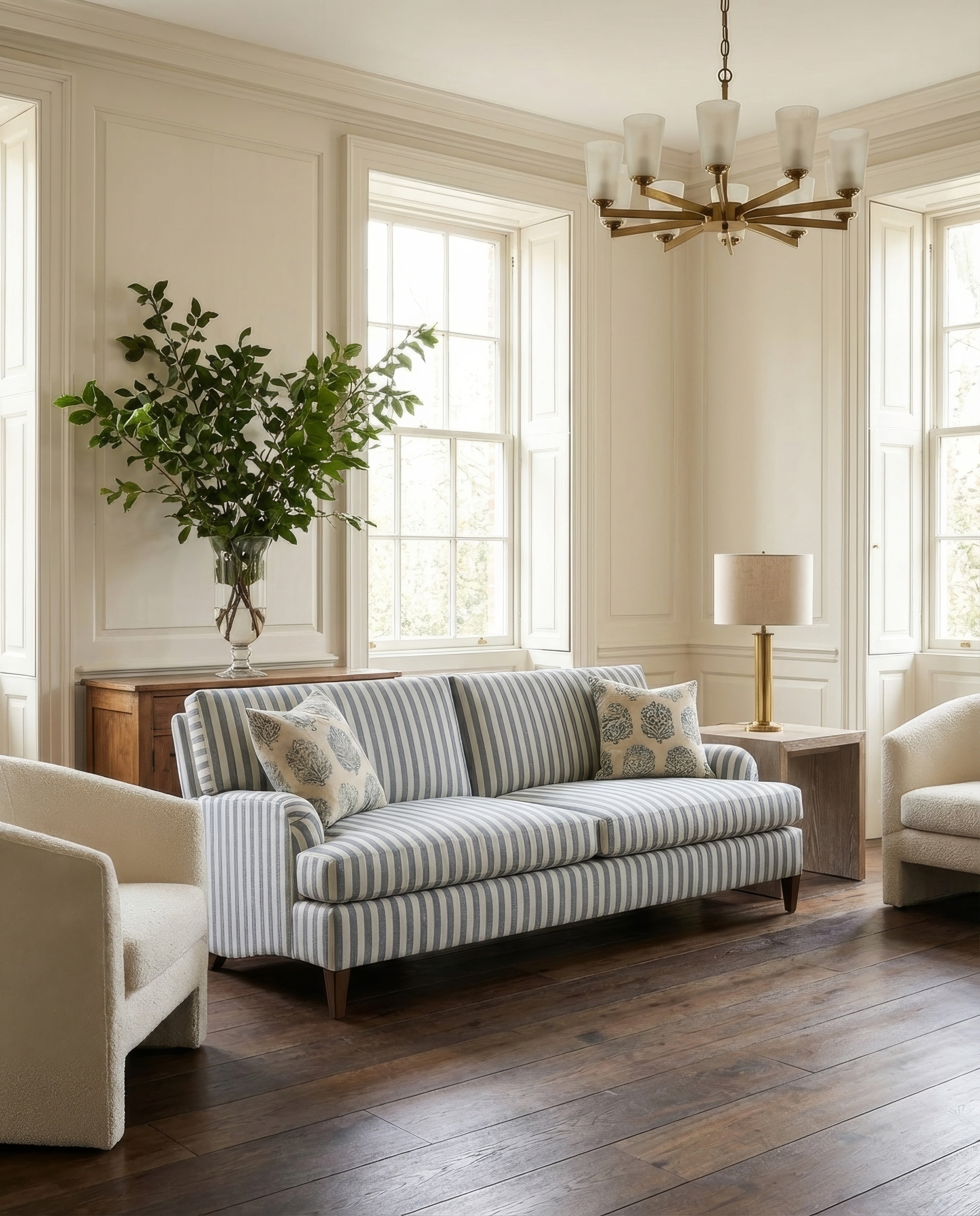 Living room with striped sofa, lamp, and plant
