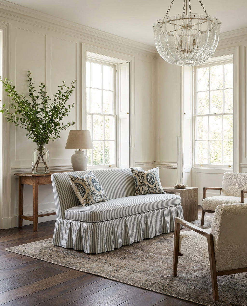 Living room with a striped sofa, armchair, and decorative elements.