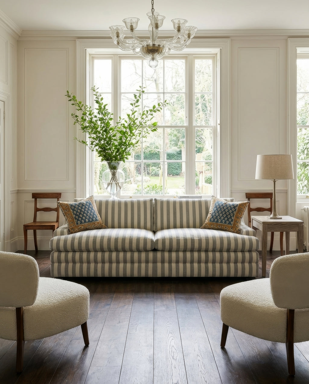 Living room with striped sofa, chairs, and large window